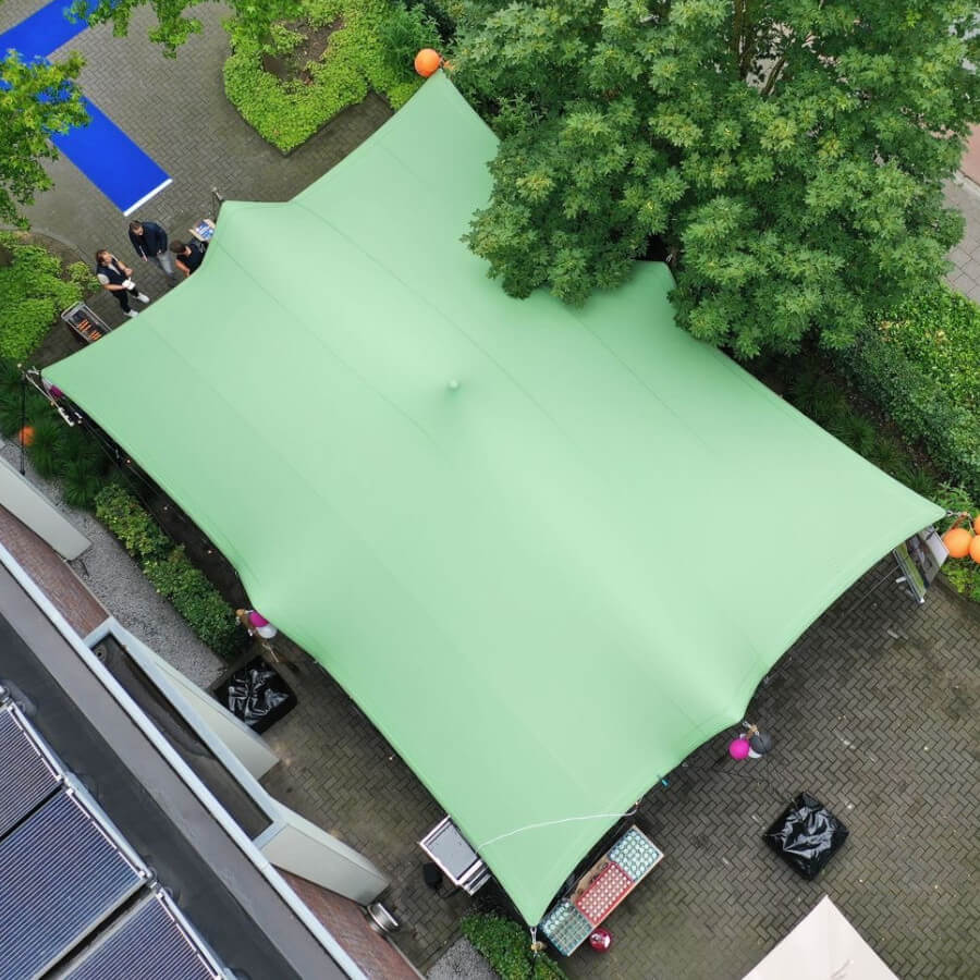 Close-up van een Forest Green Stretchtent (7,5x10 meter) op locatie bij vanBos Barneveld. De tent heeft een rijke groene kleur en is strak gespannen, geschikt voor evenementen en buitengebruik. De omgeving is goed zichtbaar met de tent in focus, waarbij de vorm en het materiaal van de tent duidelijk naar voren komen.