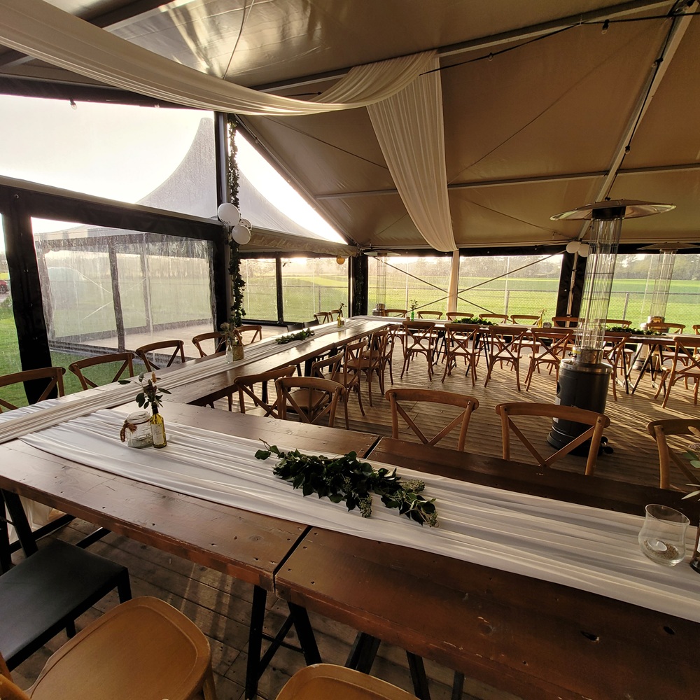 Zandkleurige aluhal tent huren met doorzichtige zijkanten voor bruiloft, huwelijk of bedrijfsfeest vanbos tenten