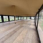 Een stretchtent zijwand met zwart PVC kader en transparant folie aan de zijkant van een evenementen stretchtent