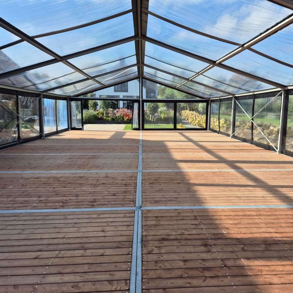 Zwaarlastvloer 2,5x5 m met houten planken inleg onder een aluhal kast tent als verankering, robuuste waterpast gestelde tentvloer te huur bij vanBos tenten.